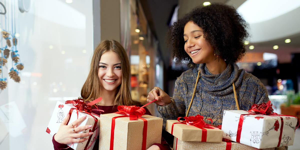Two women holding holiday gifts